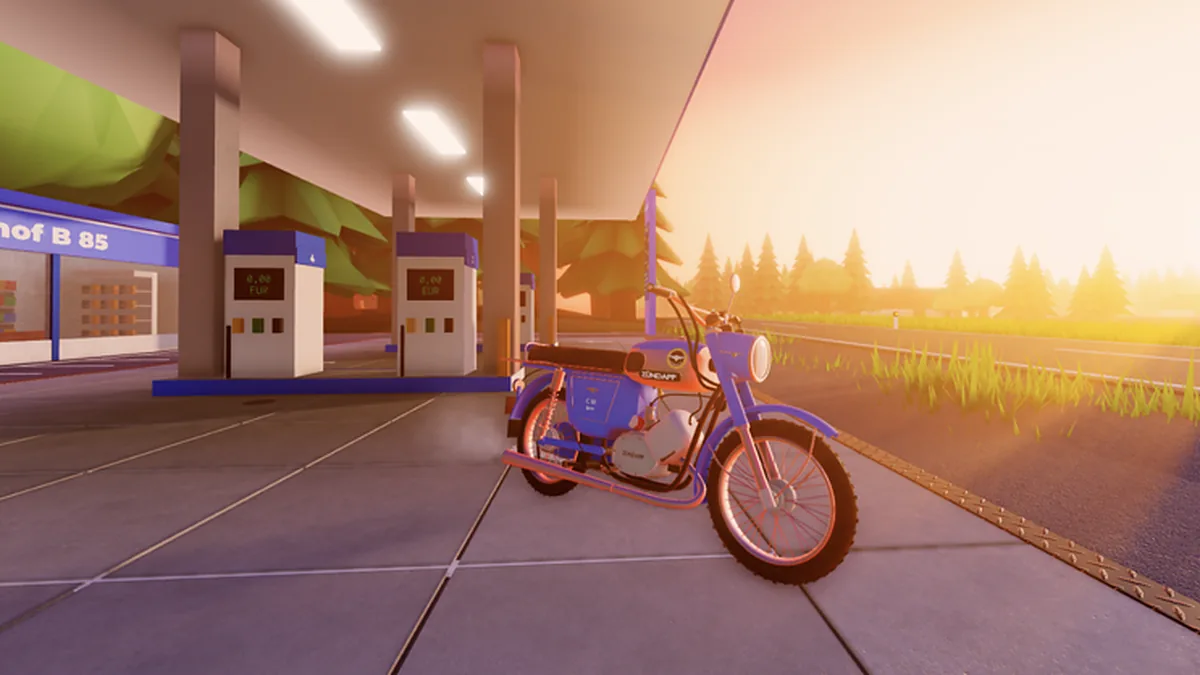 A blue Simson S51 at a fuel station at sunset, with the pump price board behind it and the road running past